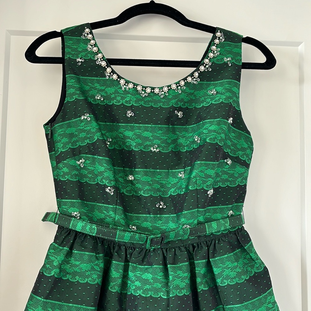 Festive green lace design dress with beautiful beading detail and belt and tule